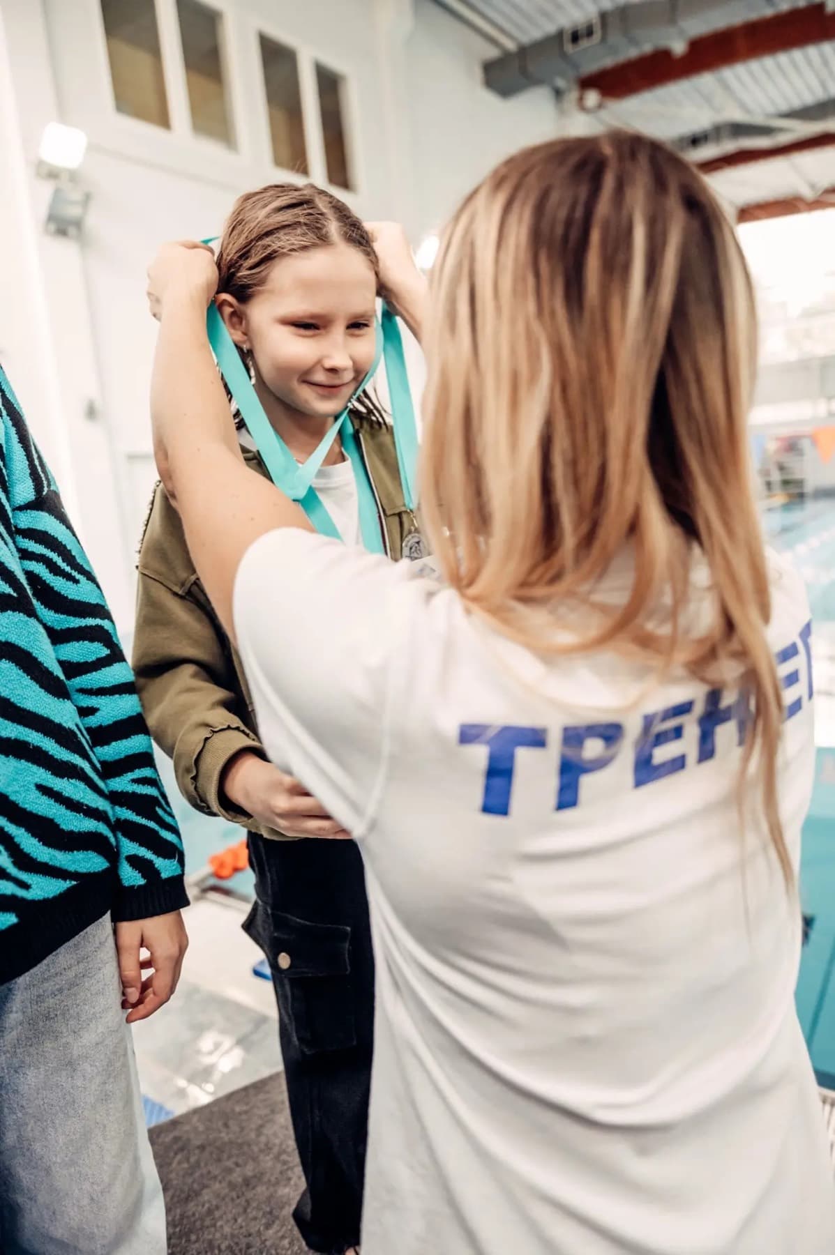 Тренер награждает ученицу медалью